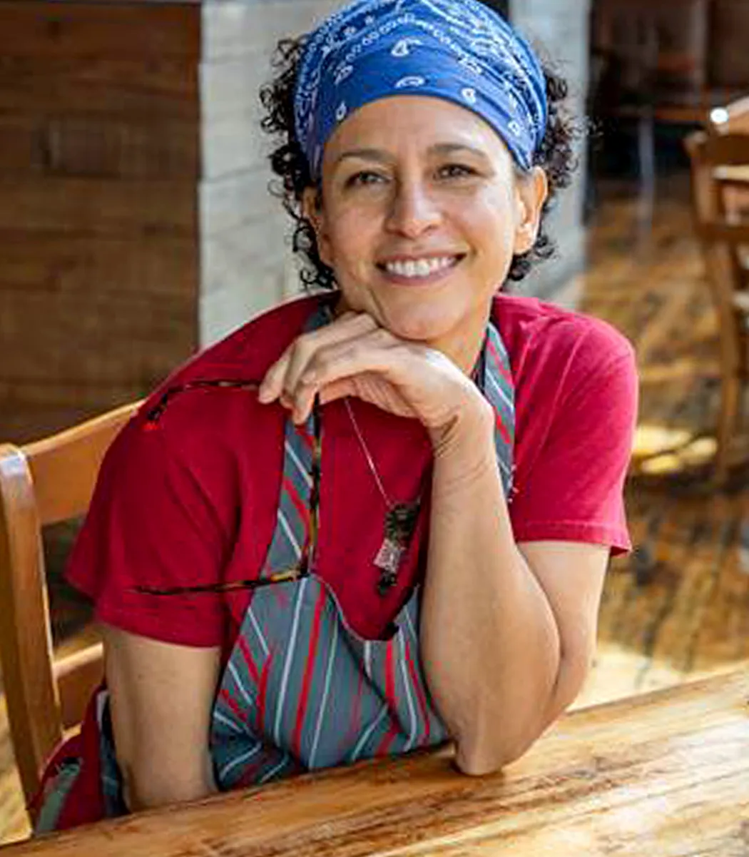 Sabrina Tinsley, co-owner and executive chef, seated at a table in the dining room.