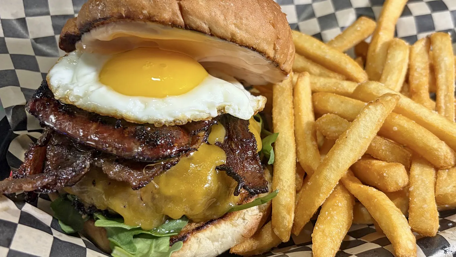 The Homage burger &mdash; an 8oz patty with cheddar, beef bacon and a fried egg on a toasted bun, served with fries.